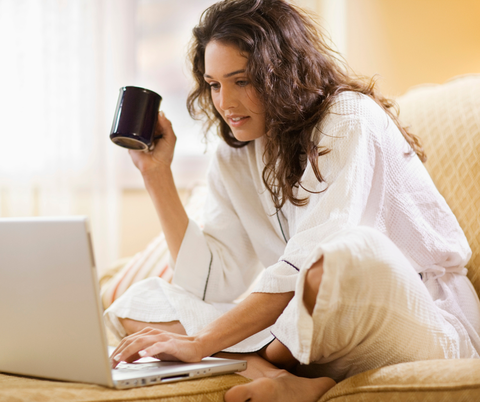 Une femme devant son ordinateur, qui crée ses publication Instagram, un café à la main